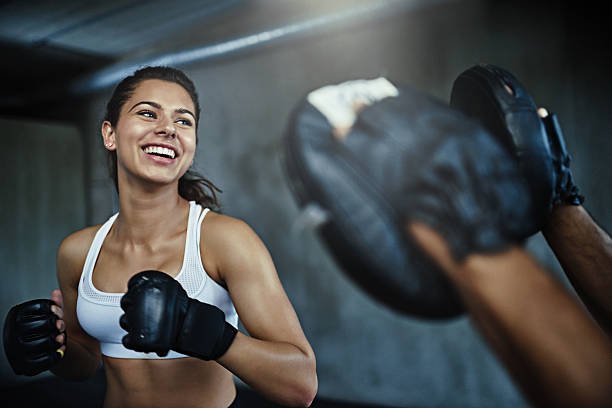 shot of a young woman sparring with a boxing partner at the gym